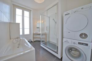 een witte badkamer met een wasmachine en een wastafel bij Papeete 3 bedrooms in Reims
