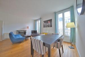 een woonkamer met een eettafel en stoelen bij Papeete 3 bedrooms in Reims +20 foto's