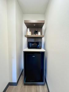 a small kitchen with a microwave on a shelf at Mission Inn San Luis Obispo in San Luis Obispo