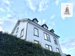 a white house on top of a hill at Pension in Beuggen