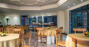 a restaurant with tables and chairs and a bar at Hotel Casa Laureles in Medellín