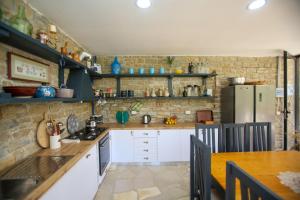a kitchen with white cabinets and a brick wall at Oda Tozaj in Kallarat