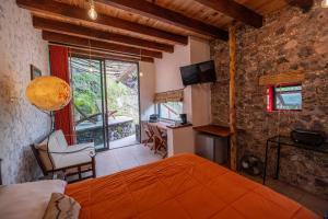 a bedroom with an orange bed and a chair and a window at Tecuán-Calli in Tepoztlán