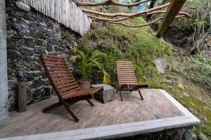 two wooden chairs sitting on a wooden deck at Tecuán-Calli in Tepoztlán