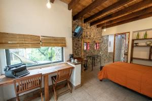 a bedroom with a desk and a bed and a window at Tecuán-Calli in Tepoztlán