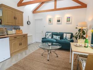 a living room with a blue couch and a table at Lighthouse in Penzance