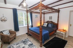 a bedroom with a canopy bed and a chair at Lighthouse in Penzance