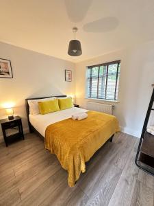 StoughtonにあるContemporary Comfort 2 Bed Homeの黄色い毛布が掛けられた大きなベッドのある寝室