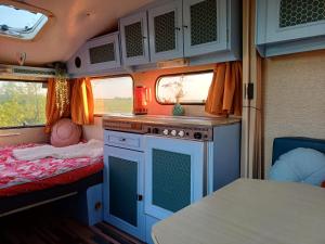 un interno di un camper con cucina e letto di Retro caravan de Duif vlakbij het Sneekermeer a Terzool