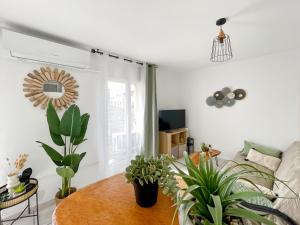 a living room with a table and potted plants at St Martial Sète centre, CLIM in Sète