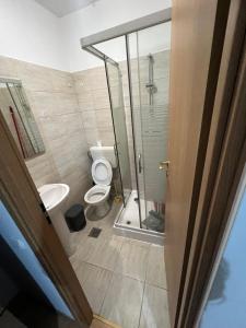 a bathroom with a toilet and a glass shower at Studio Chic in Bucharest