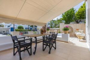 a patio with a table and chairs on a patio at Flash House Memories in Spetses
