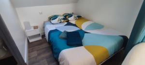 a small bedroom with a bed with colorful pillows at Studio centre ville Rodez in Rodez +2 photos