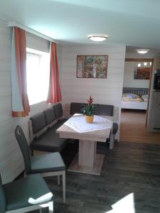 ein Esszimmer mit einem Tisch und Stühlen sowie ein Zimmer mit in der Unterkunft Ferienwohnung Angela in Steindorf am Ossiacher See