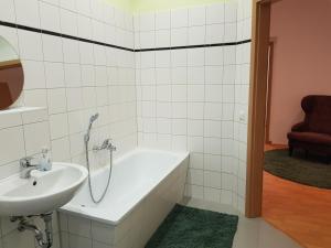 une salle de bain avec une baignoire et un lavabo dans l'établissement Apartment Ferienglück - Zentraler Rückzugsort, à Neuruppin