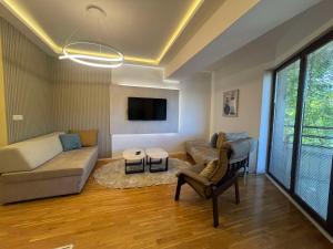 a living room with a couch and a tv at Gigi Apartment by eluxory in Skopje