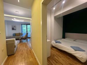 a bedroom with a bed and a living room at Gigi Apartment by eluxory in Skopje