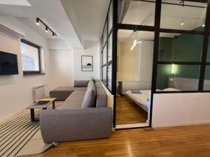 a living room with a couch and a bed at Gigi Apartment by eluxory in Skopje