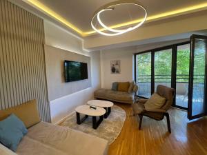 a living room with a couch and a table at Gigi Apartment by eluxory in Skopje