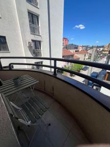 a balcony with a table and a view of a street at Gigi Apartment by eluxory in Skopje