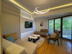 a living room with a couch and a table at Gigi Apartment by eluxory in Skopje