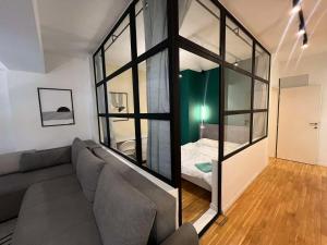 a living room with a couch and a bedroom at Gigi Apartment by eluxory in Skopje