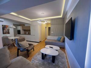a living room with a couch and a table at Gigi Apartment by eluxory in Skopje