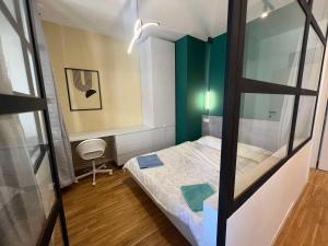 a small bedroom with a bed and a mirror at Gigi Apartment by eluxory in Skopje