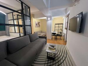 a living room with a couch and a flat screen tv at Gigi Apartment by eluxory in Skopje