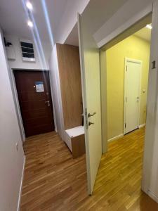 a hallway with a door and a room with wooden floors at Gigi Apartment by eluxory in Skopje