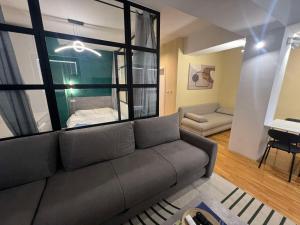 a living room with a couch and a bedroom at Gigi Apartment by eluxory in Skopje