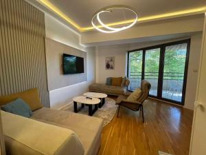 a living room with a couch and a table at Gigi Apartment by eluxory in Skopje