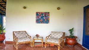 two chairs and a table with a painting on the wall at Casa em Cabo Frio com acesso direto à praia in Cabo Frio