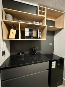 a kitchen with a black counter top and a microwave at Estudio cerca del Movistar Arena in Santiago +24 photos