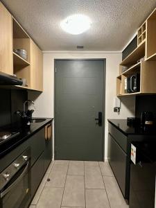 a kitchen with a green door in a kitchen at Estudio cerca del Movistar Arena in Santiago