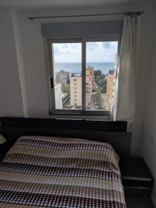 a bedroom with a bed and a large window at Remolins Bloque 2 9B Benicàssim zona Torreón in Benicàssim