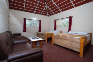 a living room with two beds and a couch at The Peacock Village Eco Resort & Spa in Amrutūr +70 photos