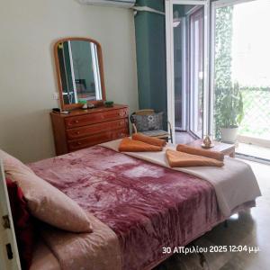 ein Schlafzimmer mit einem großen Bett und einem großen Spiegel in der Unterkunft Cozy & Bright Home - 50m from metro station Άg Antonios in Athen
