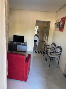 een woonkamer met een rode bank en stoelen bij Casa Aconchegante Odc in Olho D’Água do Casado