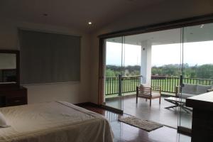 Casa Blanca HaciendaCasa de Campo 15 people with a pool的一间卧室设有一张床和一个阳台的大窗户 更多25张照片