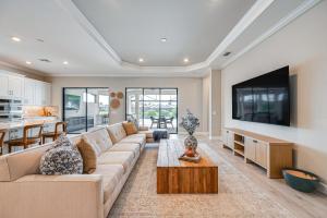 a living room with a couch and a tv at Golf, Swim, Shop and More Luxury Retreat in Naples! in Naples