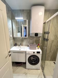 a bathroom with a washing machine and a sink at Sea & Stone Edge Suites in Dobra Voda +16 photos