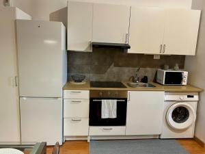 a kitchen with white cabinets and a refrigerator at Ubicacion inigualable in Vigo