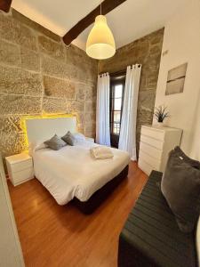 a bedroom with a large bed and a stone wall at Ubicacion inigualable in Vigo