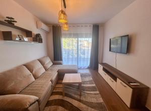 a living room with a couch and a tv at Sea & Stone Edge Suites in Dobra Voda