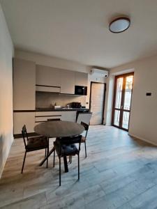 a kitchen with a table and chairs in a room at La Morra Apartments in La Morra