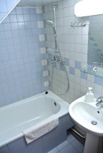 La salle de bains blanche est pourvue d'une baignoire et d'un lavabo. dans l'établissement Cabana Tei, à Azuga