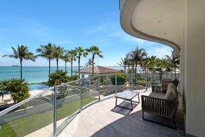 a balcony with a view of the ocean and palm trees at Cable Beach condo with ocean views in Nassau