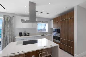 a kitchen with a white counter top and wooden cabinets at Cable Beach condo with ocean views in Nassau +37 photos