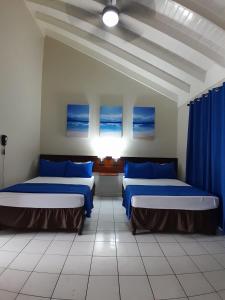two beds in a room with blue sheets at Beach Studio 27 in Ocho Rios